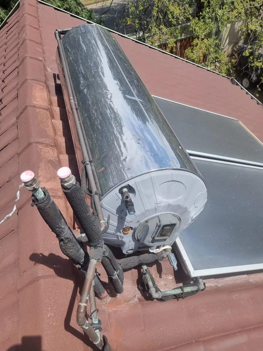 established Solahart style solar geyser system on a residential roof